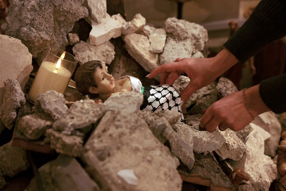 Instalação retrata Jesus Cristo deitado na manjedoura em meio a escombros — Foto: Hazem Bader/AFP