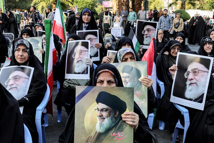 Iranianos protestam contra Israel em Teerã segurando fotos do líder supremo do país, Ali Khamenei, e do líder morto do Hezbollah, Hassan Nasrallah