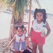 Juliana, com 2 anos, na companhia da irmã Mariana (criança maior) brincando na praia; longe das telas de celulares — Foto: Álbum de família