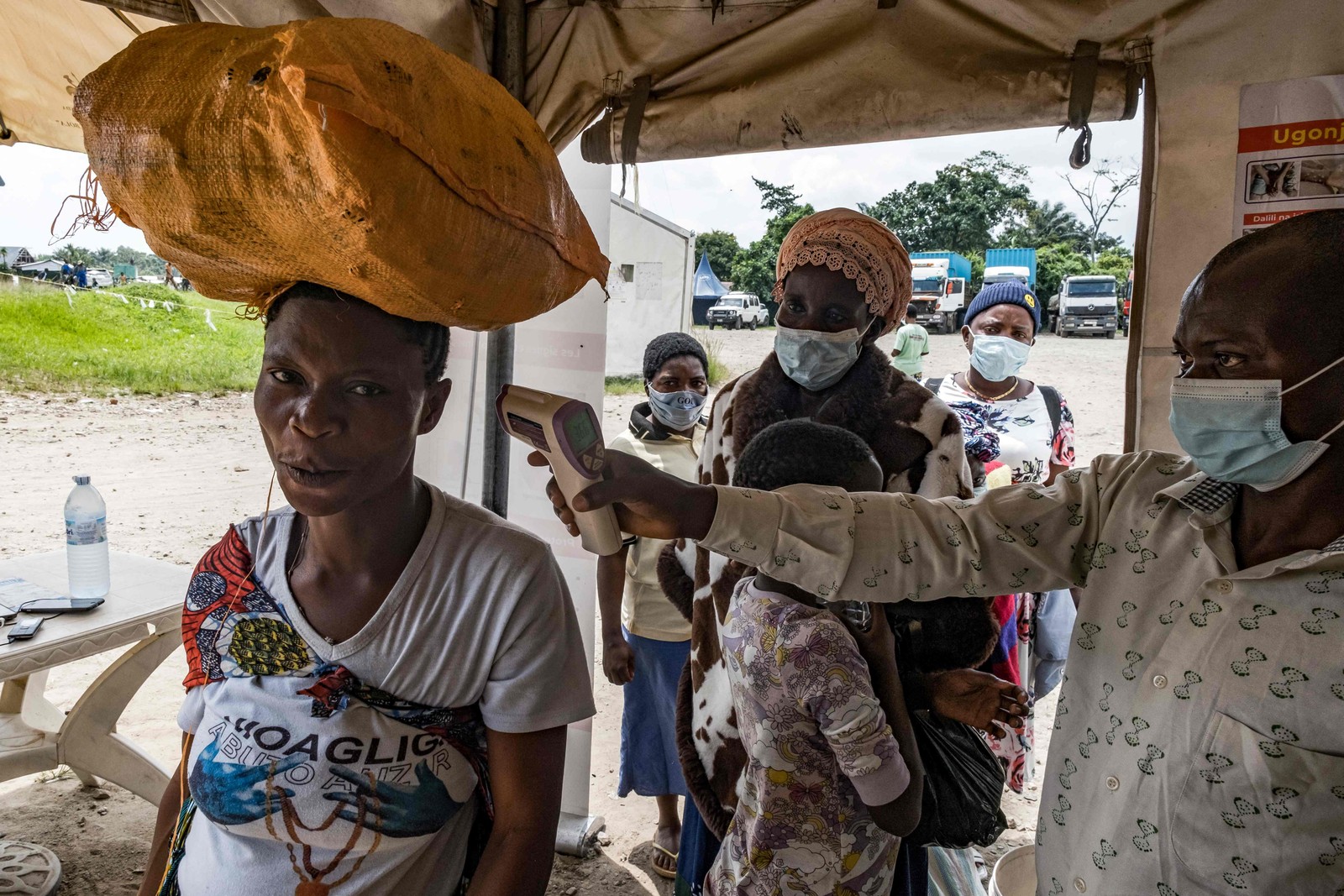 Um agente de sa&uacute;de fronteiri&ccedil;o na passagem entre Uganda e a Rep&uacute;blica Democr&aacute;tica do Congo, verifica a temperatura de um viajante &mdash; Foto: Badru KATUMBA / AFP