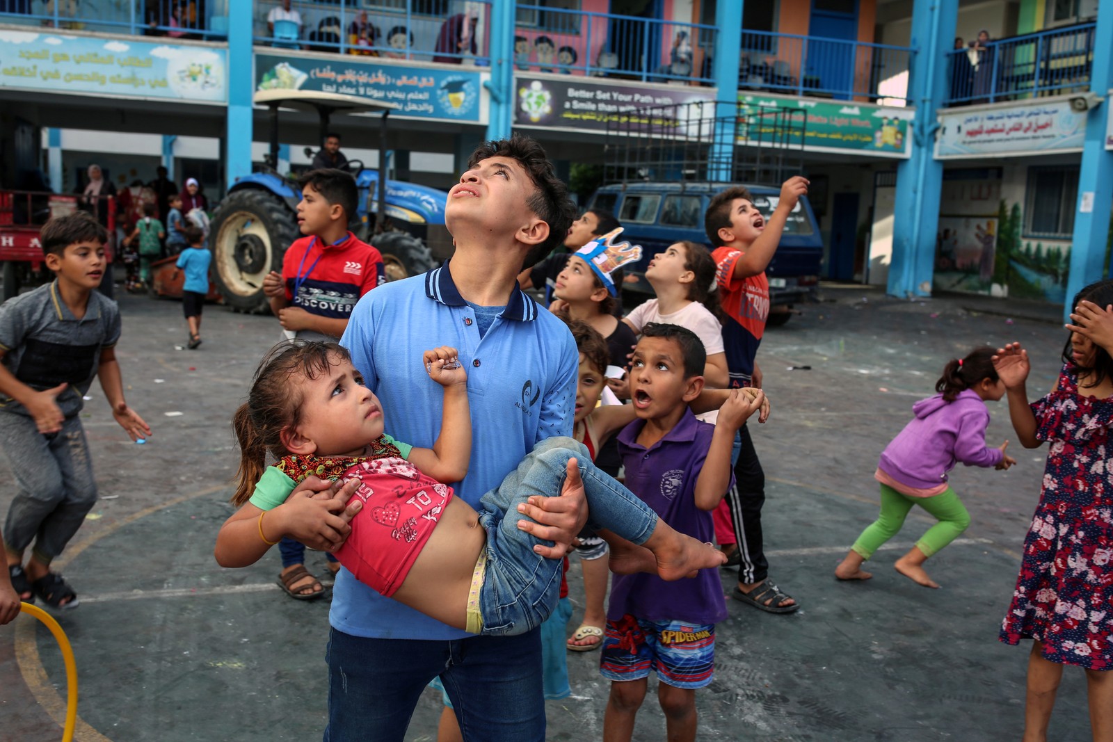 Crianças palestinas que buscam abrigo em uma escola na Cidade de Gaza olham para o céu enquanto jatos israelenses sobrevoam, uma das primeiras respostas de Israel ao ataque terrorista do Hamas. — Foto: Samar Abu Elouf/The New York Times