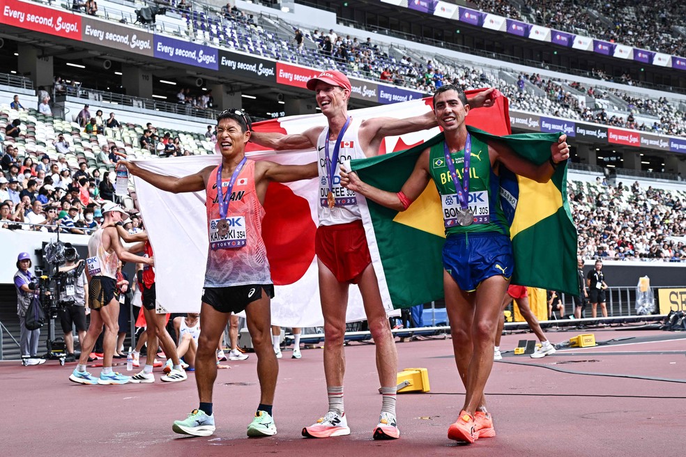 O japonês Hayato Katsuki (bronze), o canadense Evan Dunfee (ouro) e Caio Bonfim (prata): celebração na pista — Foto: Jewel Samad/ AFP