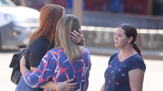 Na foto, Tais Oliveira (de preto) segura a irmã de Daniel Patrício Oliveira — Foto: Fabiano Rocha / Agência O Globo