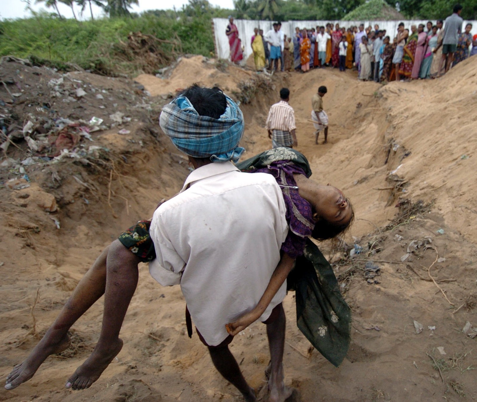Homem carrega o corpo da filha em Cuddalore, na Índia, em 27 de dezembro de 2004 — Foto: Prakash Singh / AFP