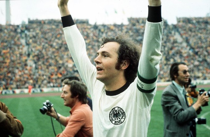 O 'Kaiser' ergue os braços com a camisa da Alemanha
