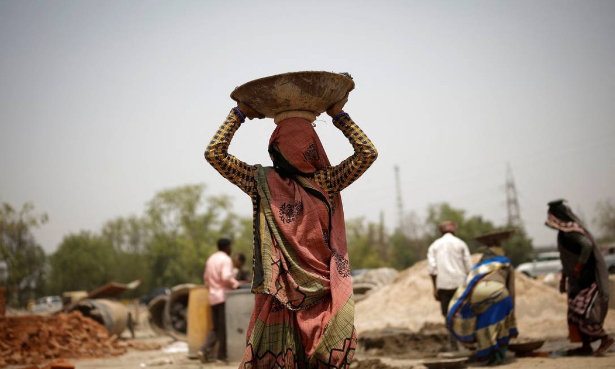 Trabalhadores em um canteiro de obras em Nova Délhi. Partes da Índia testemunharam os mais quentes meses de março e abril já registrados em 122 anos da série histórica — Foto: ADNAN ABIDI / REUTERS