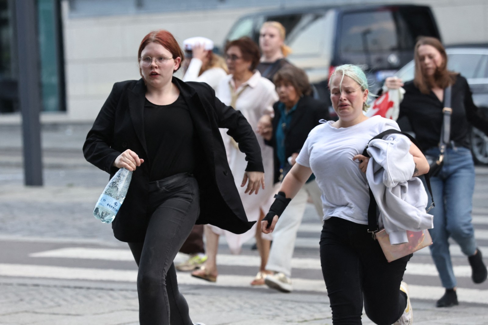 Clientes deixam o shopping correndo durante evacuação do prédio após disparos de armas de fogo — Foto: Olafur Steinar Gestsson / Ritzau Scanpix / AFP