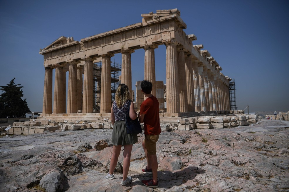 Casal visita as ruínas da Acrópole em Atenas, Grécia — Foto: Aris Messinis / AFP