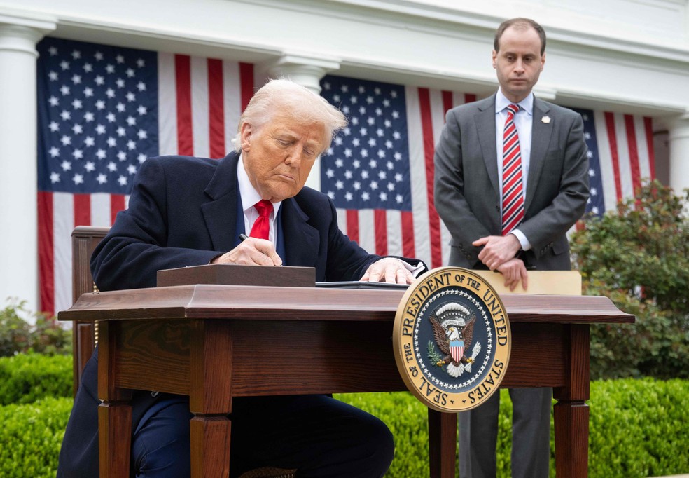 O presidente dos EUA, Donald Trump, assina ordem executiva que impõe tarifas recíprocas — Foto: Saul Loeb/AFP