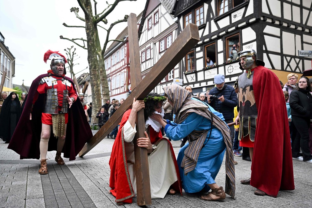 Espectadores observam a reencenação da crucificação de Jesus Cristo em Bensheim, no oeste da Alemanha, — Foto: Kirill Kudryavtsev / AFP)