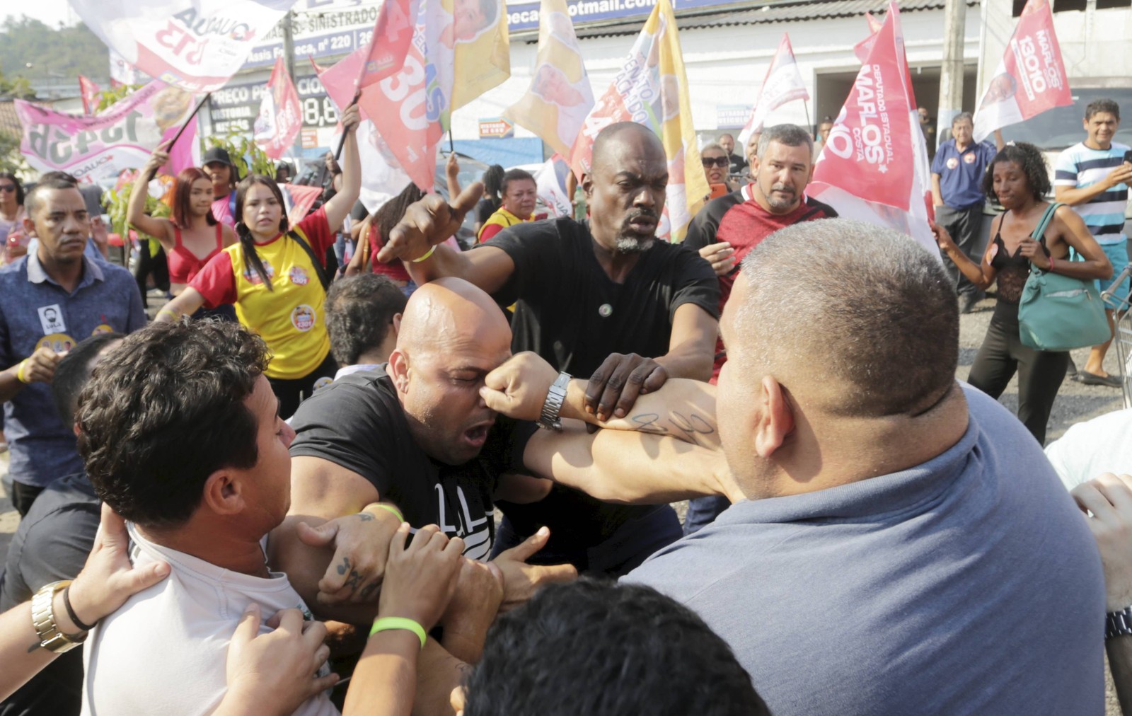 Petistas e Bolsonarista brigam na frente do Clube Tamoio, em São Gonçalo. Na foto, Rodrigo Duarte, apoiador do presidente, leva um soco durante o evento.  — Foto: Domingos Peixoto / Agência Globo