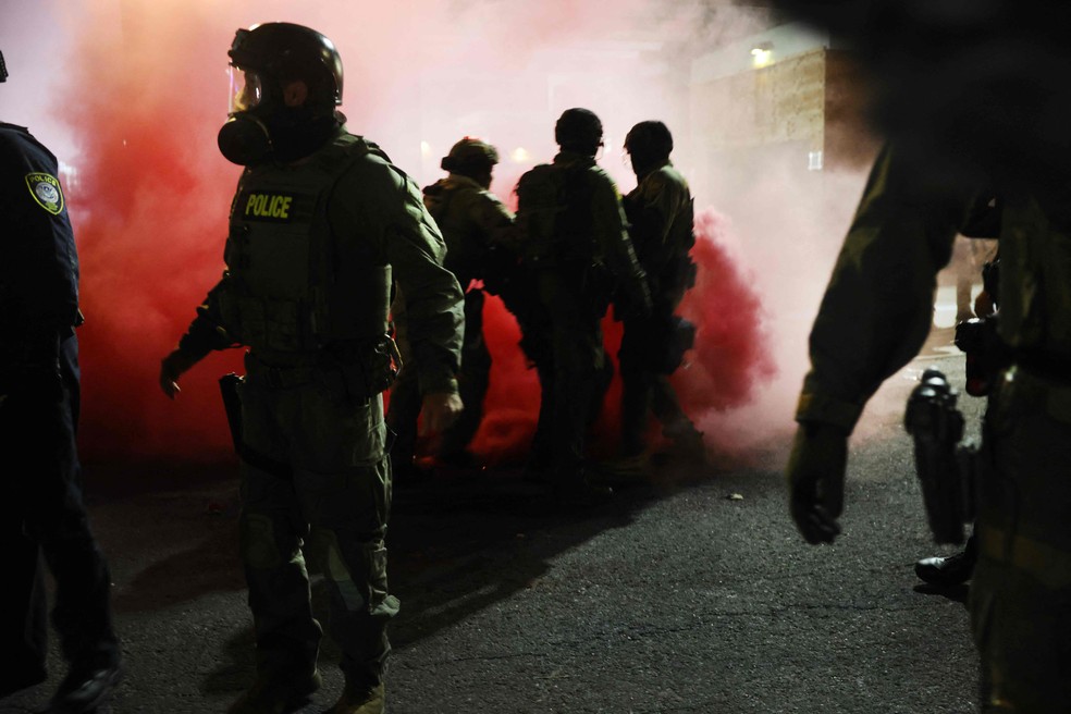 Agentes federais, incluindo membros do Departamento de Segurança Interna, da Patrulha de Fronteira e da polícia, tentam conter manifestantes do lado de fora de uma instalação do Serviço de Imigração e Alfândega dos EUA em Portland — Foto: Spencer Platt/Getty Images/AFP