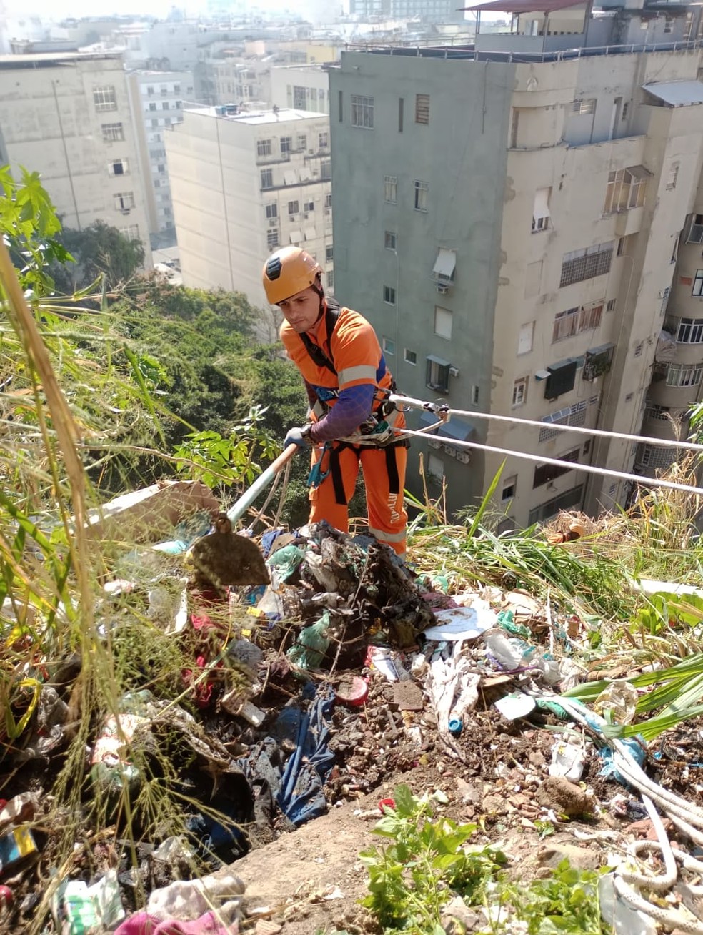 Pás. Os garis alpinistas usam ferramentas pesadas para remover o lixo — Foto: Divulgação/Comlurb