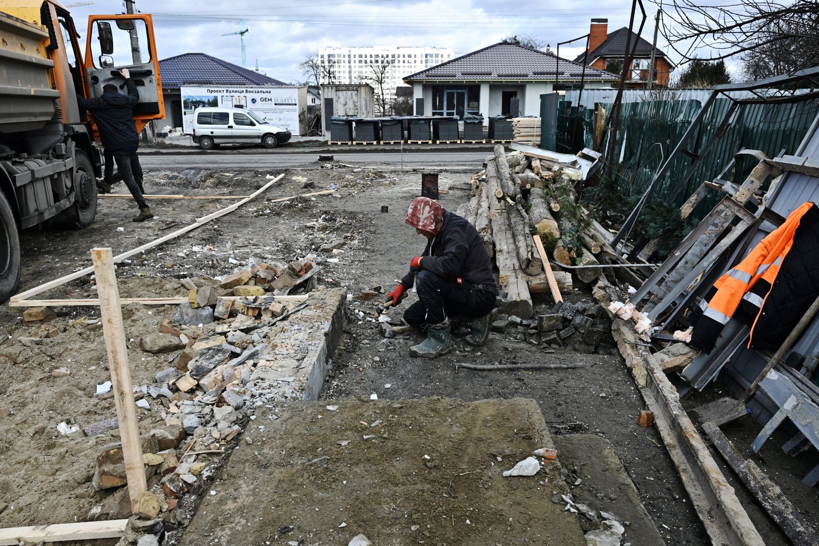 Trabalhadores se preparam para construir uma nova casa no lugar de outras destruídas ao longo da rua Vokzalna, em Bucha — Foto: Genya SAVILOV / AFP - 14/02/2023