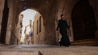 Monge caminha em beco da antiga Jerusalém; clima entre judeus e muçulmanos na cidade é de desconfiança — Foto: Ahmad Gharabli/AFP