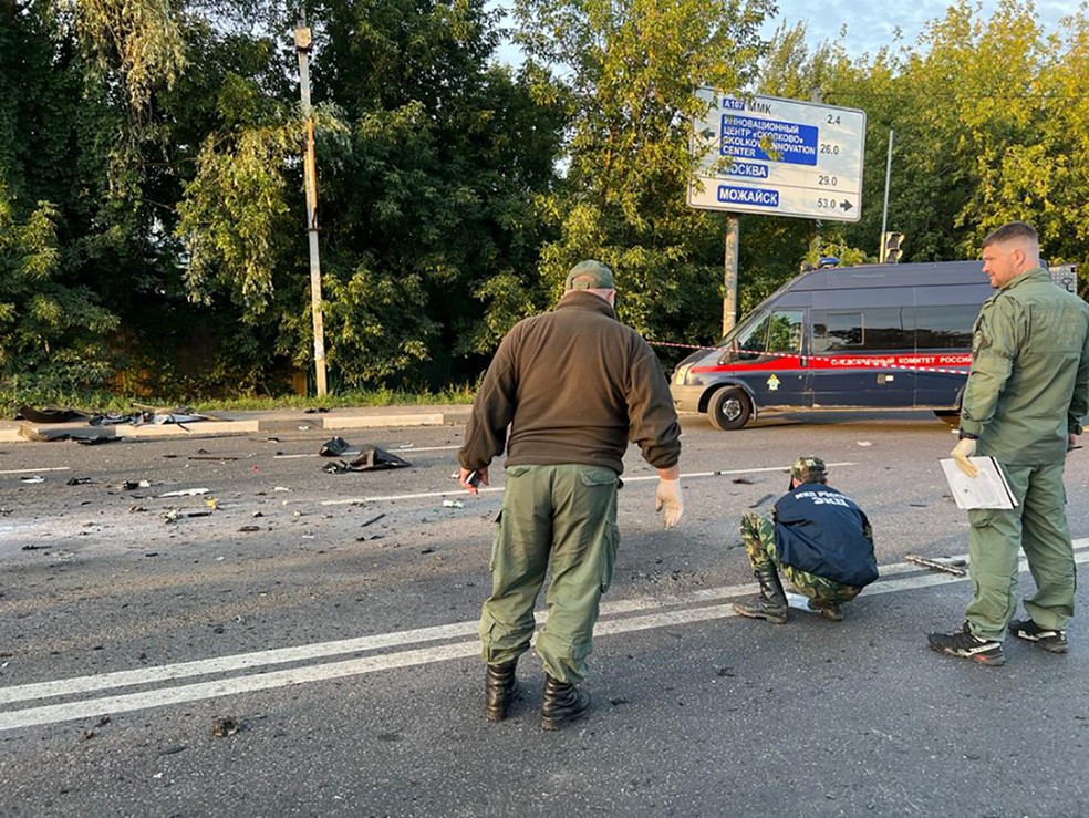 Policiais analisam local onde ocorreu atentado contara Darya Dugina, nos arredores de Moscou — Foto: Comissão Investigativa da Rússia / AFP