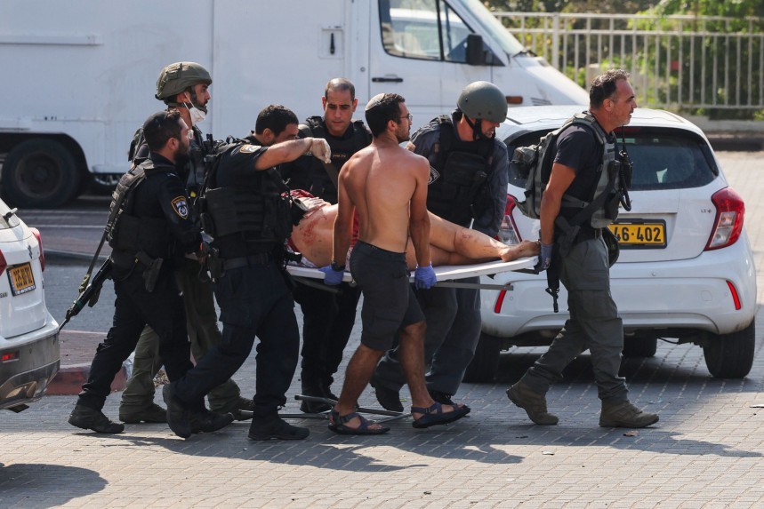 Membros das forças de segurança israelenses carregam uma pessoa ferida em uma maca após um ataque com foguetes da Faixa de Gaza em Ashkelon, sul de Israel – AHMAD GHARABLI / AFP