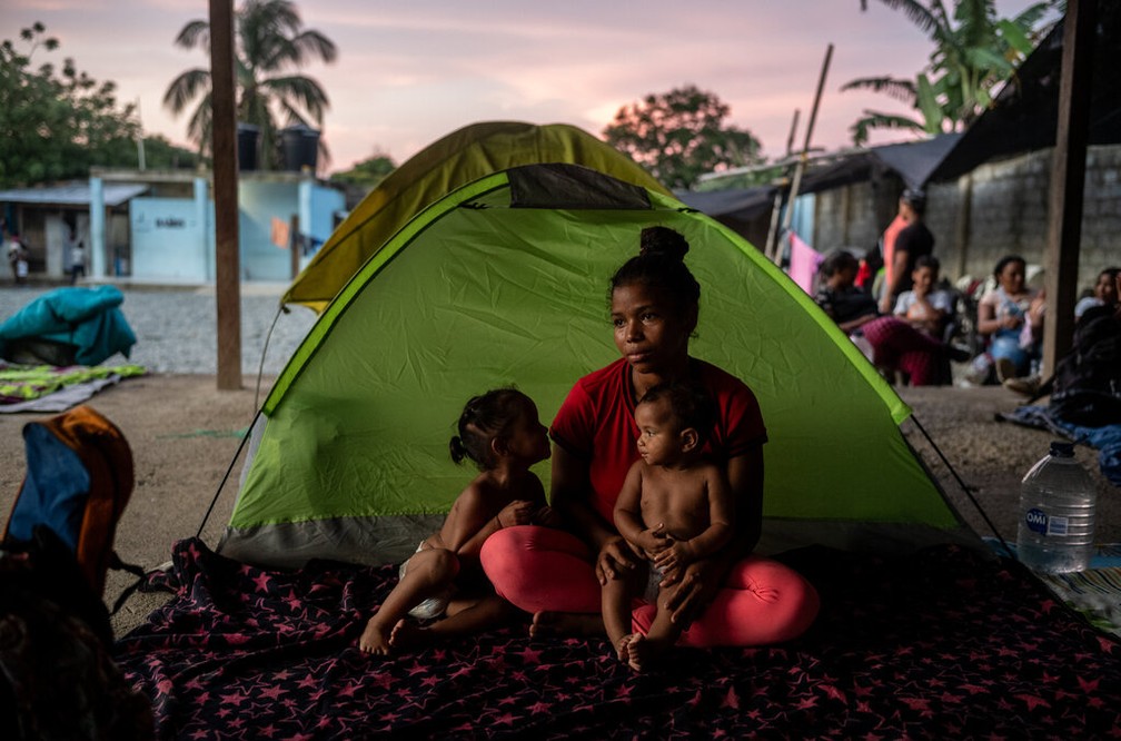 Mãe e filhos aguardam para prosseguir no trajeto de travessia da selva de Darién — Foto: Federico Rios / NYT