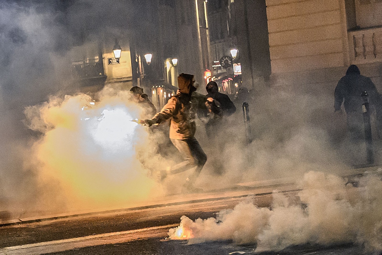 Homem lança um coquetel molotov contra policiais durante manifestaçãoem Nantes, oeste da França — Foto: LOIC VENANCE / AFP