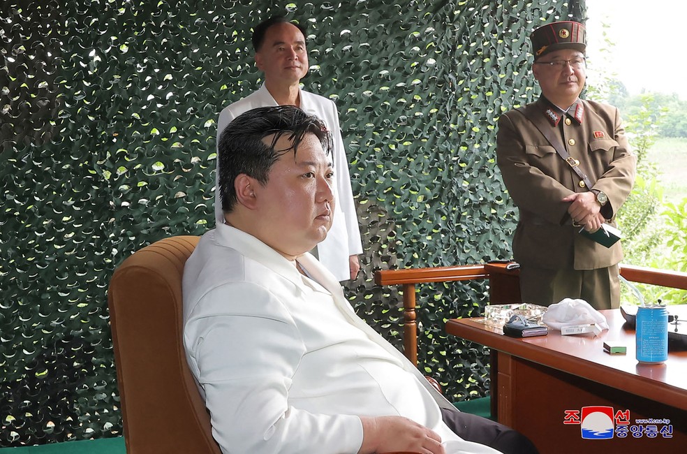 Fotos divulgadas pelo jornal oficial Rodong Sinmun mostram um celular prateado com capa de couro preto na mesa de Kim Jong-Un  Foto: KCNA VIA KNS / AFP