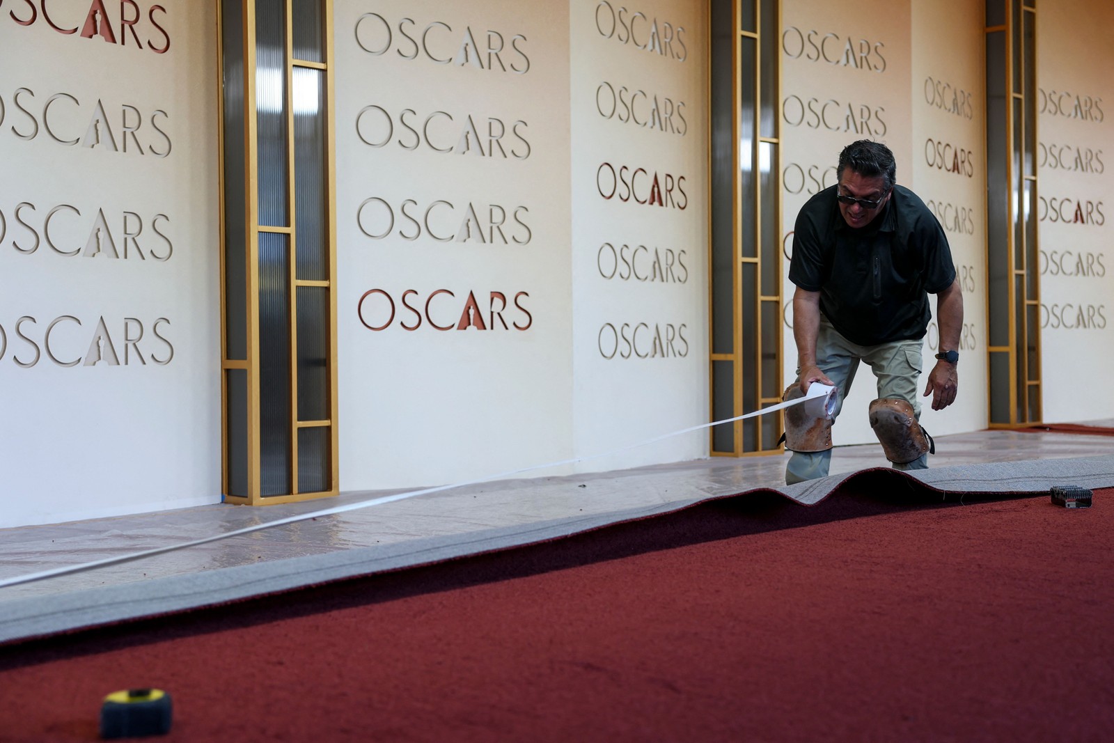 Funcionário coloca o tapete vermelho na área de entrada onde a 98ª cerimônia do Oscar acontece — Foto: ANGELA WEISS / AFP