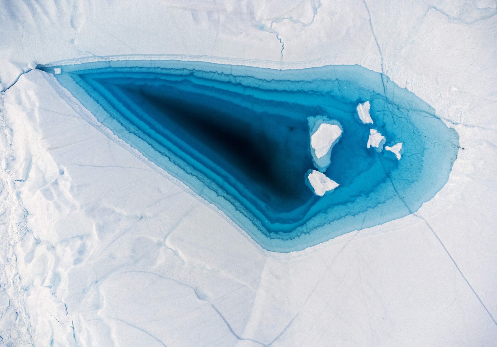 A água azul-turquesa é vista em um grande buraco de derretimento no topo de um iceberg na baía de Disko, Ilulissat, oeste da Groenlândia, em 29 de junho. — Foto: Odd ANDERSEN / AFP