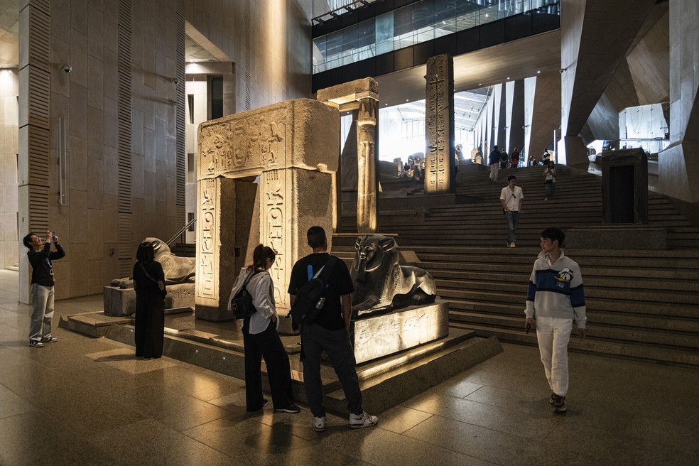 Visitantes no Gran Hall, o grande átrio de entrada do Grande Museu Egípcio, cujo principal destaque é a estátua de nove metros de altura de Ramnsés II — Foto: Stephen Hiltner/The New York Times