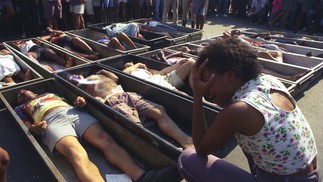 Mulher chora diante dos corpos de moradores de Vigário Geral assassinados por um grupo de extermínio, integrado por PMs, na madrugada de 29 de agosto de 1993. A imagem chocante correu o mundo — Foto: Custodio Coimbra