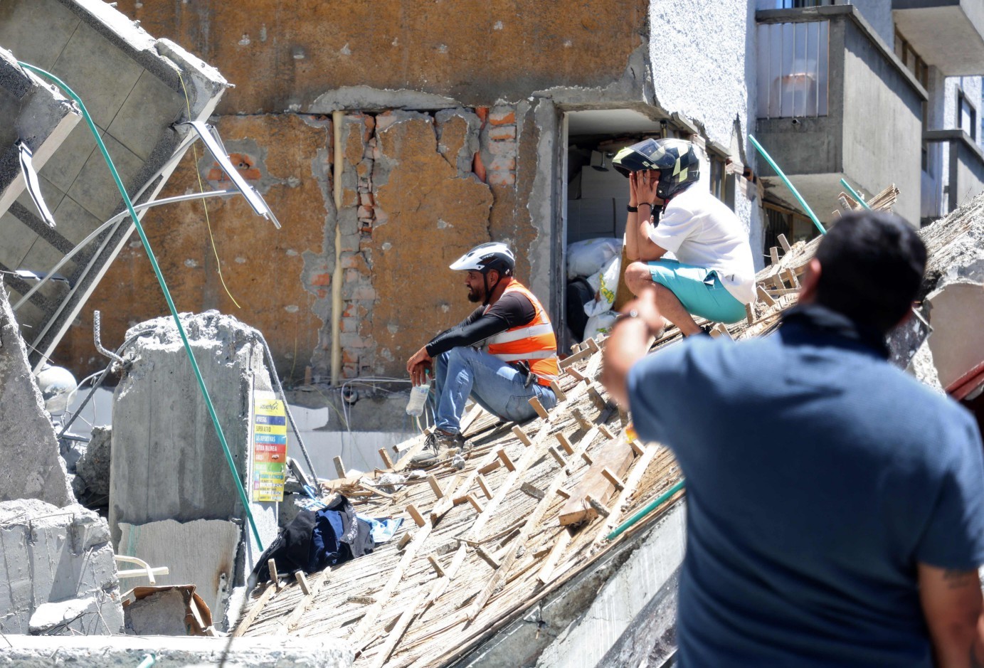 Pessoas observam um edifício desabado após um terremoto em Manizales, Colômbia. — Foto: Giovanny Galvez / AFP