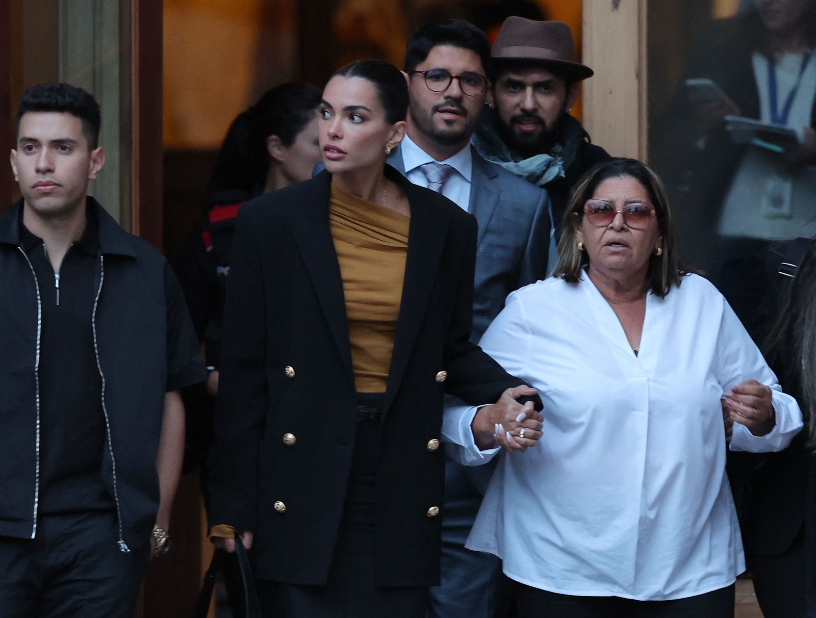 Esposa de Daniel Alves, Joana Sanz, de mãos dadas com a mãe do ex-jogador, Lucia Alves, saem do segundo dia de julgamento — Foto: LLUIS GENE