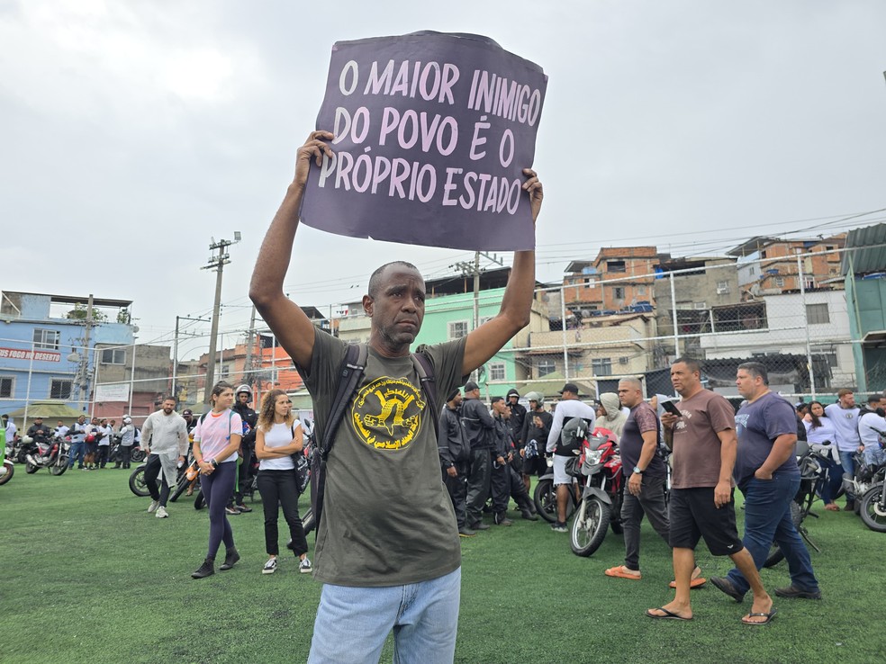 Selmo levanta cartaz durante a concentração do ato desta sexta-feira — Foto: Léo Martins / Agência O Globo