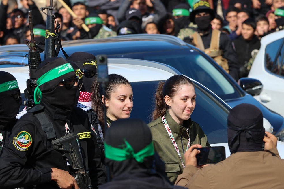 Reféns israelenses sendo entregues pelo Hamas para uma equipe da Cruz Vermelha, na Cidade de Gaza — Foto: AFP/Omas Al-Qattaa